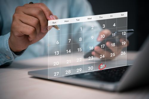 Foto: Nahaufnahme einer Person, die einen digitalen Kalender auf einem Laptop verwendet